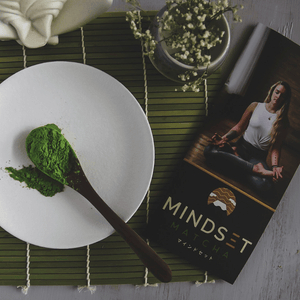 Matcha on a plate beside meditating woman photo and mindset matcha logo